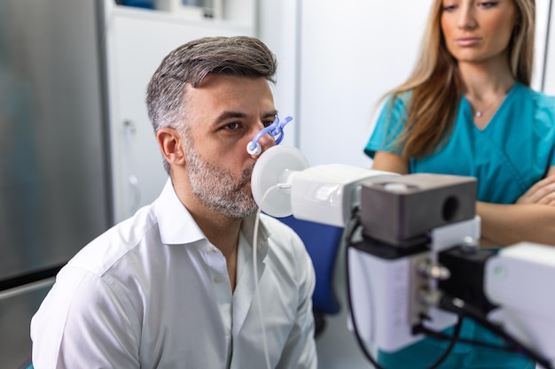 Hombre adulto que prueba la función respiratoria por espirometría con problemas de salud Diagnóstico de la función respiratoria en la enfermedad pulmonar