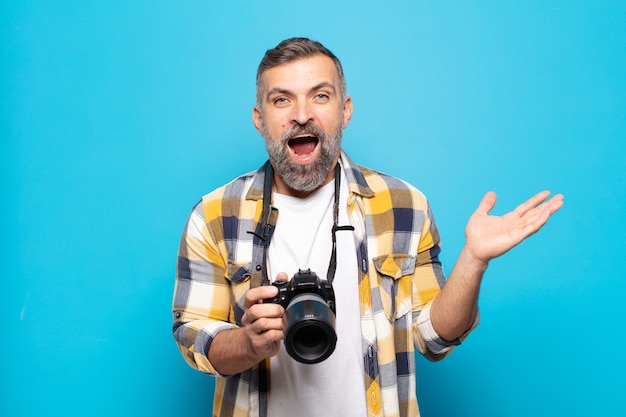 Hombre adulto que se siente feliz, emocionado, sorprendido o conmocionado, sonriendo y asombrado por algo increíble