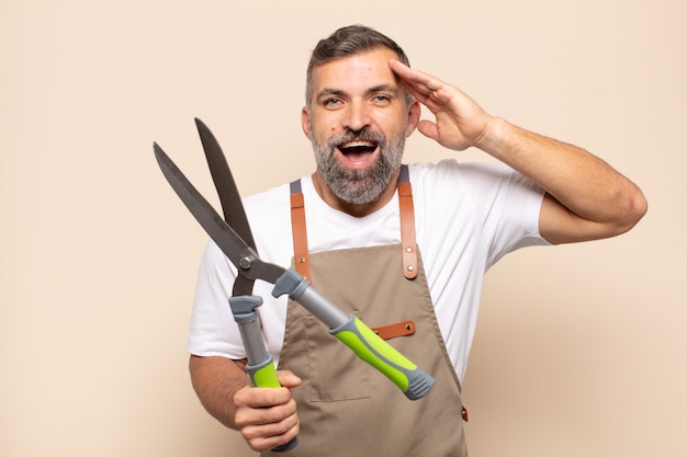 Hombre adulto que se ve feliz, asombrado y sorprendido, sonriendo y dándose cuenta de buenas noticias increíbles e increíbles