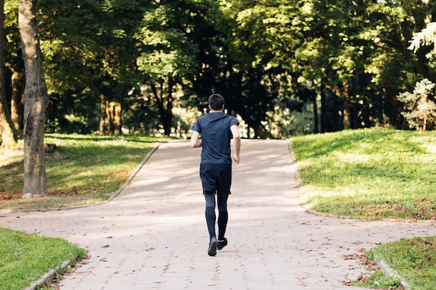 Hombre adulto en ropa deportiva para correr en el parque temprano en la mañana