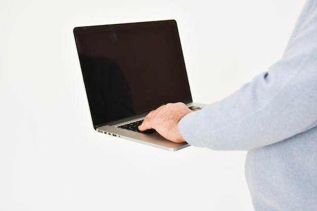 Hombre adulto sosteniendo un ordenador portátil aislado sobre fondo blanco. Copie el espacio.