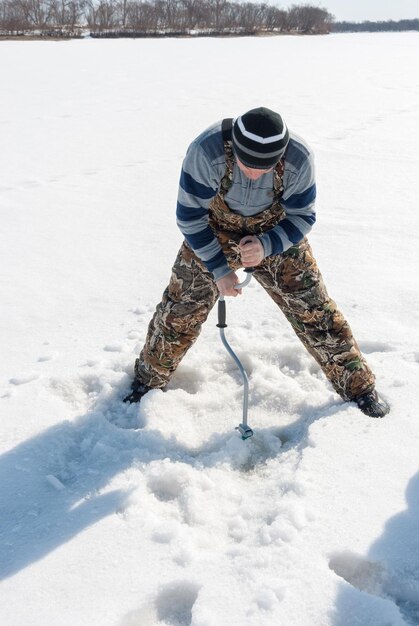 Foto hombre adulto subglacial pescando en un lago congelado