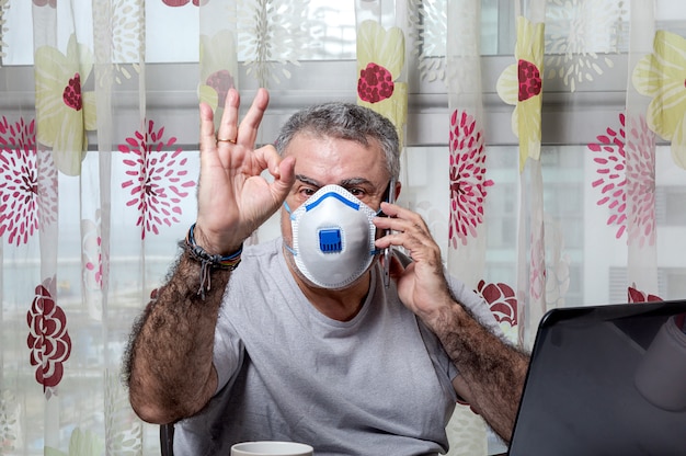 Foto hombre adulto trabajando en casa con máscara protectora