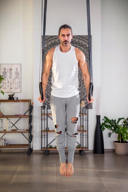 Hombre adulto trabajando en ring dips en el gimnasio