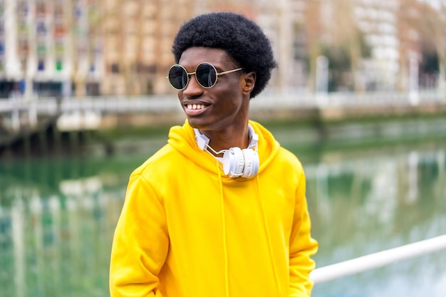 Hombre africano elegante con gafas de sol de pie al aire libre