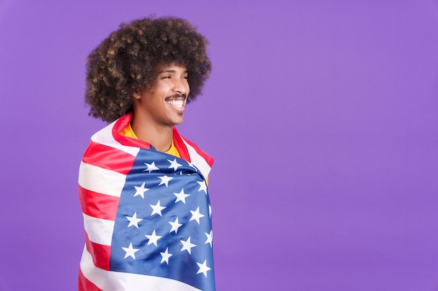 Hombre africano de ensueño envolviendo con una bandera nacional de américa del norte