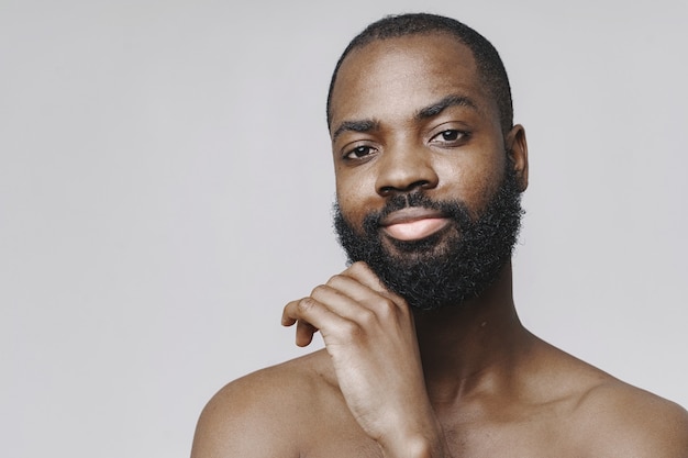 Foto hombre africano en un estudio. pared blanca. hombre sin ropa.