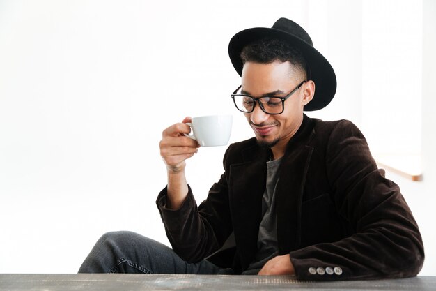 Hombre africano feliz que sostiene la taza de café