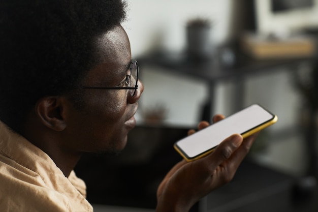 Hombre africano leyendo un mensaje en el teléfono