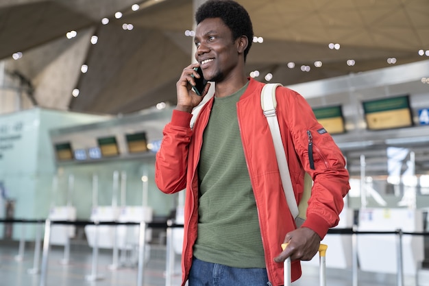 Hombre africano llamando a un taxi en el aeropuerto