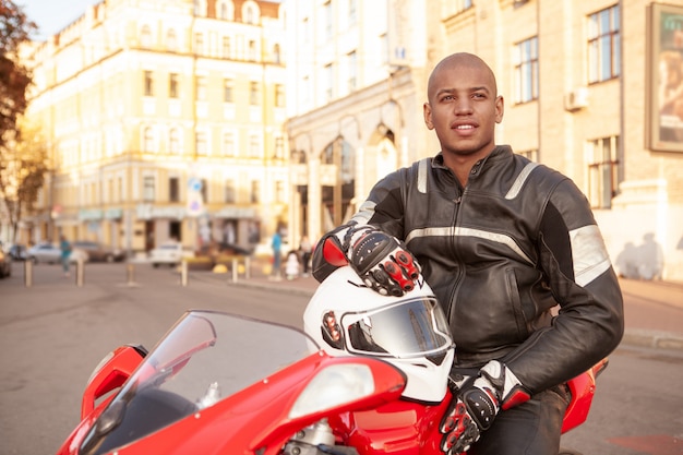 Hombre africano en una moto deportiva en la ciudad