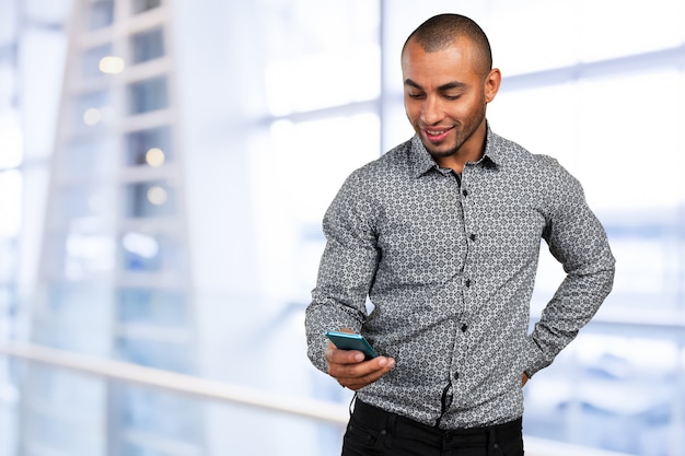 Hombre africano negro joven feliz con el teléfono celular