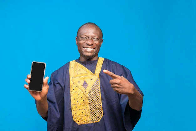 Hombre africano negro sonriente sosteniendo y señalando el teléfono móvil en la mano