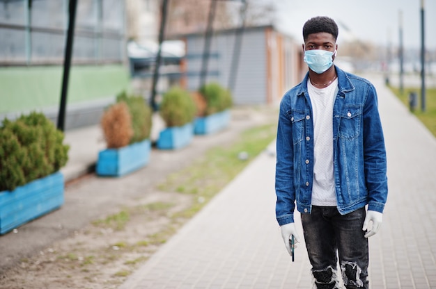 El hombre africano en el parque con máscaras médicas protege contra infecciones y enfermedades por el virus de coronavirus en cuarentena.