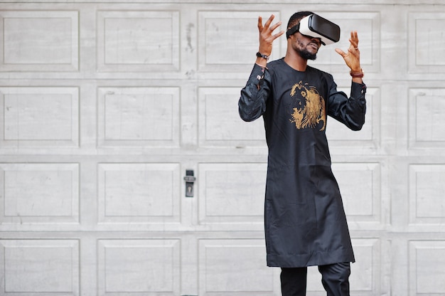 Hombre africano rico en ropa tradicional con estilo en gafas vr. El futuro del concepto de África.