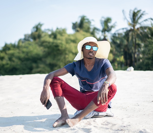 hombre africano, sentado, en, playa arenosa, solo