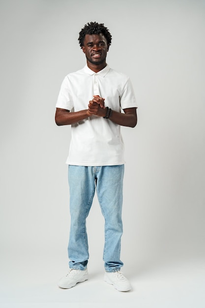 Hombre africano sonriente con camisa blanca contra un fondo gris