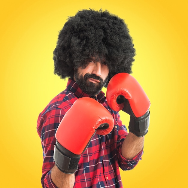 Hombre afro con guantes de boxeo sobre fondo de colores