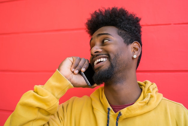 Hombre afro hablando por teléfono.