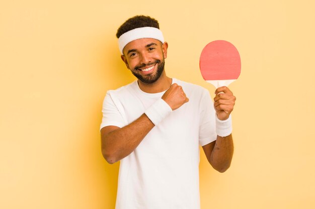 Hombre afro negro que se siente feliz y enfrenta un desafío o celebra el concepto de ping pong