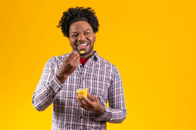 Hombre afro en traje de fiesta de junio comiendo un delicioso cural