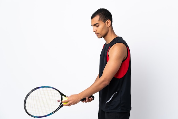 Hombre afroamericano en blanco aislado jugando al tenis