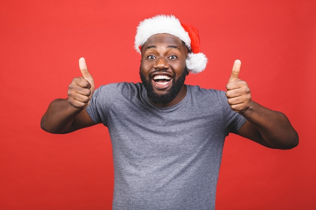 Hombre afroamericano en camiseta gris y gorro de Papá Noel