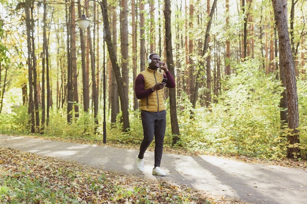 Foto hombre afroamericano escucha música en el espacio de copia de spring park y lugar para la aplicación de gadget publicitario