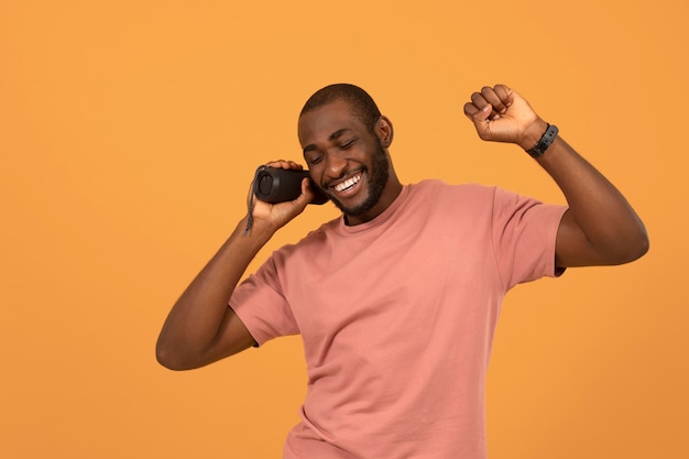 Foto hombre afroamericano escuchando música en el altavoz