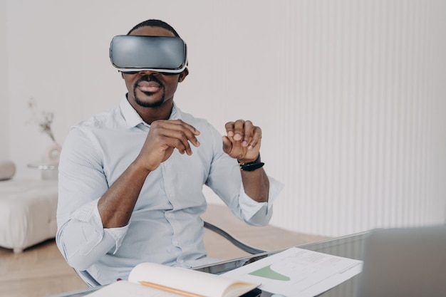 Hombre afroamericano con gafas de realidad virtual en casa El hombre de negocios tiene una reunión en línea