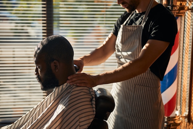 Hombre afroamericano guapo cortarse el pelo en la peluquería