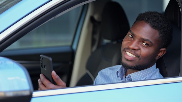 Hombre afroamericano habla con un amigo a través de videollamada en coche