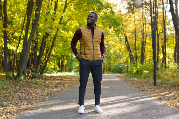 Hombre afroamericano hipster caminando en el parque otoño