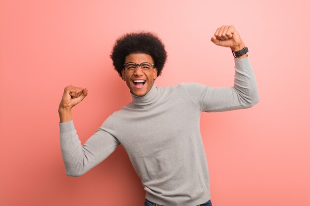 Hombre afroamericano joven sobre una pared rosada que no se rinde