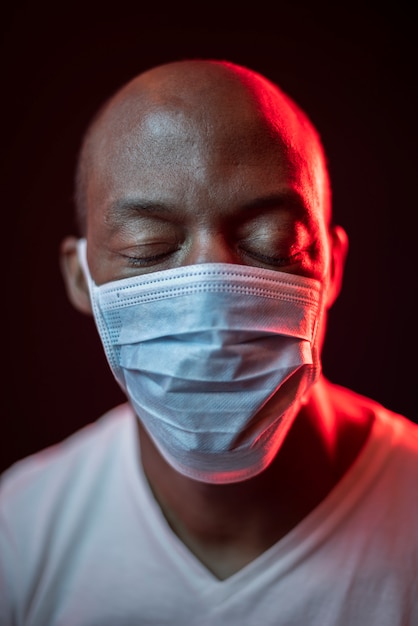 Foto hombre afroamericano con máscara protectora y ojos cerrados, concepto de coronavirus.