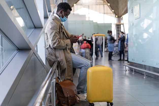 Hombre afroamericano con mascarilla en el aeropuerto