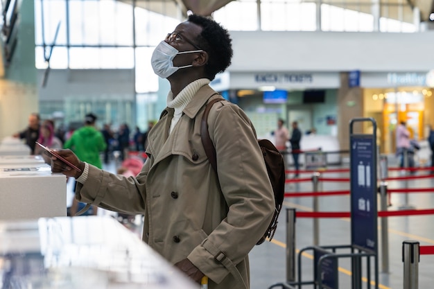 Hombre afroamericano con mascarilla en el aeropuerto