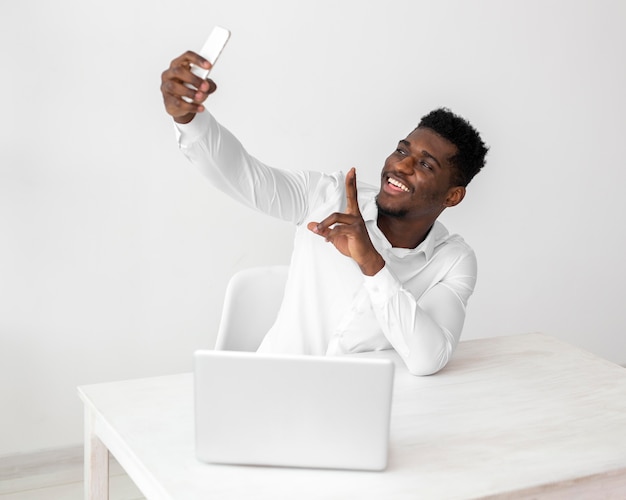 Hombre afroamericano de negocios tomando un selfie