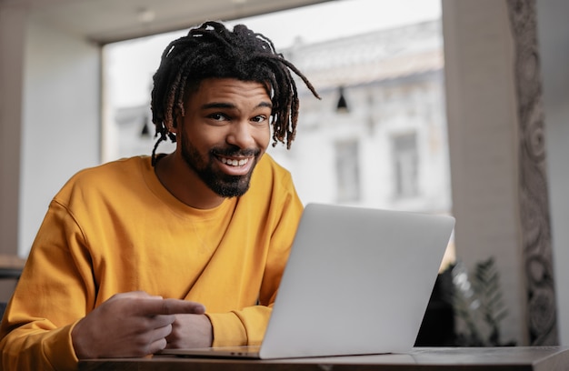 Hombre afroamericano que señala el dedo en la pantalla del portátil