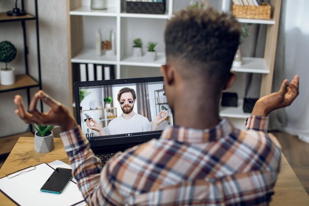 Foto hombre afroamericano que tiene videollamada con psicólogo