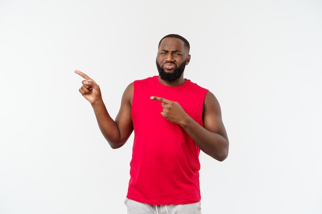 Hombre afroamericano con ropa deportiva señalando con el dedo con triste emoción.