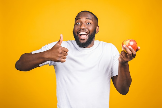 Hombre afroamericano sano que sostiene una manzana