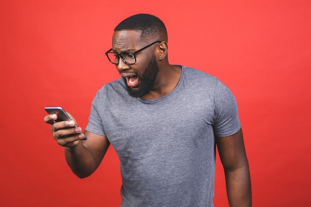 Hombre afroamericano con smartphone estresado, enojado y frustrado