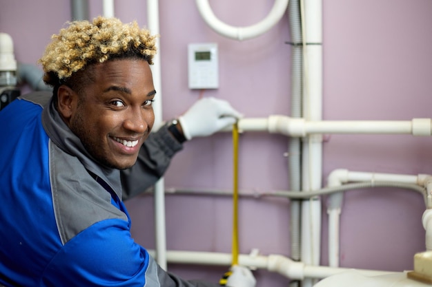 Hombre afroamericano sonriente toma medidas con una cinta métrica