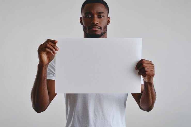 Hombre afroamericano sosteniendo una hoja de papel en un primer plano de fondo blanco Maqueta para diseño