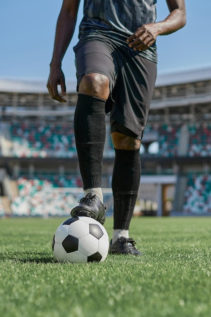 Hombre afroamericano sosteniendo una pelota de fútbol en el estadio