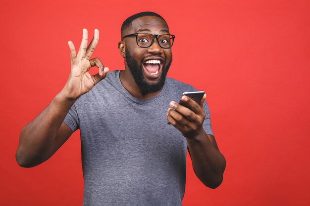 Hombre afroamericano sosteniendo smartphone y sonriendo