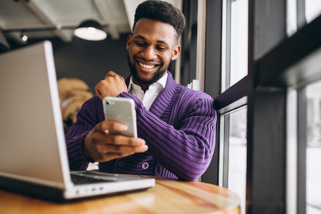 Hombre afroamericano con teléfono en un café