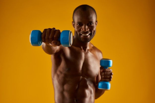 Hombre afroamericano con torso desnudo haciendo ejercicios.