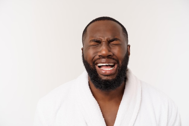 Hombre afroamericano vistiendo una bata de baño con sorpresa y emoción feliz aislado sobre fondo whtie